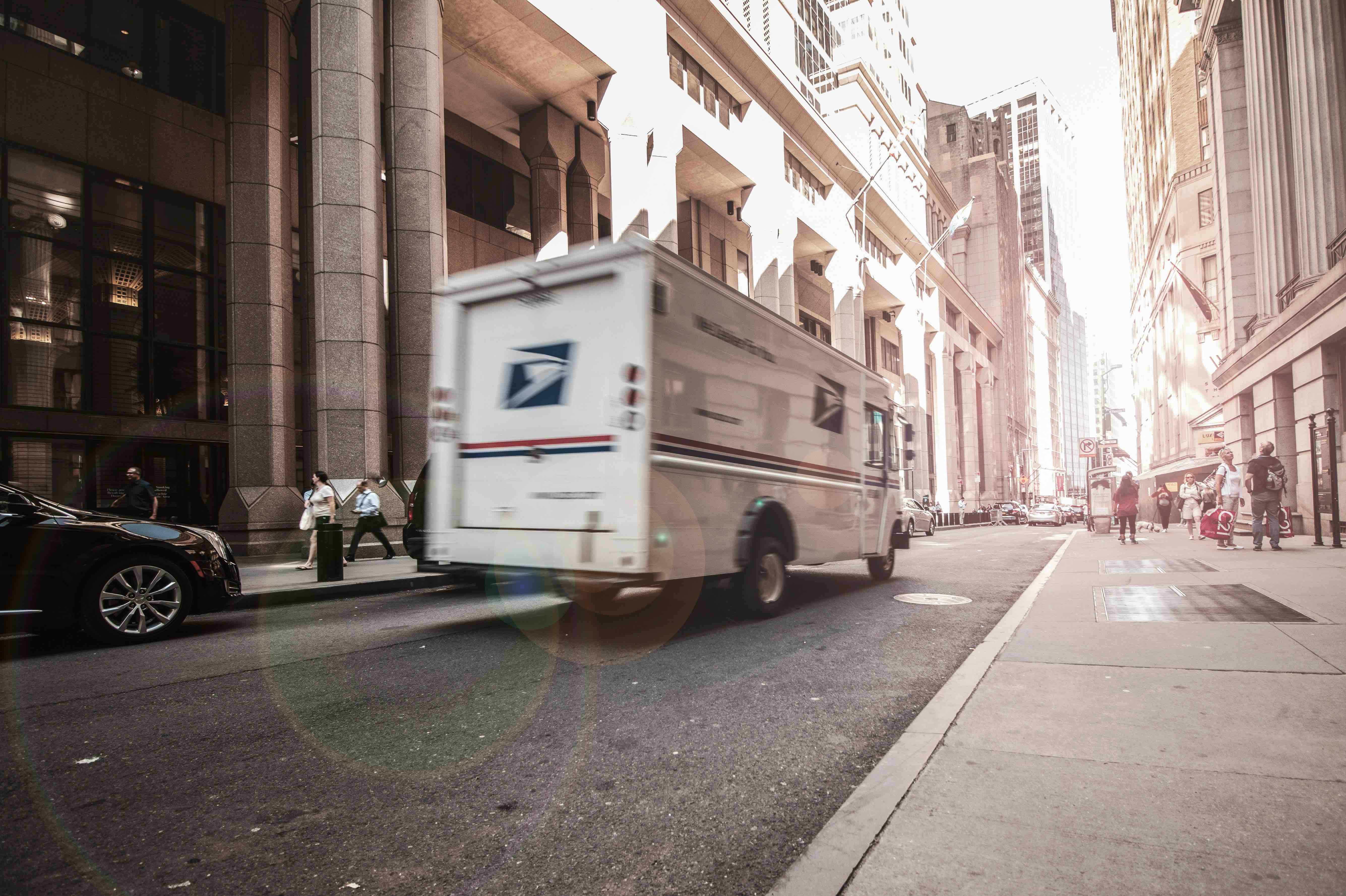 A mail truck driving down a city street.